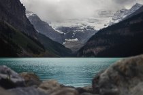 Scenic view majestic mountains beyond tranquil blue lake, Lake Louise, Alberta, Canada — Stock Photo