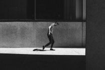 Schatten folgt Mann auf sonnigem Bürgersteig — Stockfoto