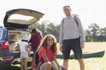 Portrait happy father and daughter camping, unloading car — Stock Photo