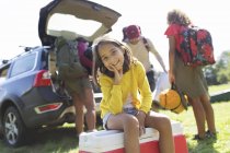 Retrato sorridente menina acampar com a família, descarga de carro — Fotografia de Stock