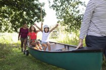 Excited family carrying canoe in woods — Stock Photo