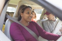 Усміхнена жінка водить машину з сім'єю в дорожній подорожі — стокове фото