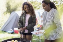 Mother and daughter barbecuing at campsite — Stock Photo