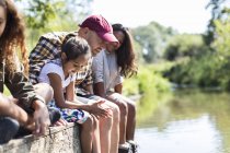 Сім'я сидить на краю річкового причалу — стокове фото
