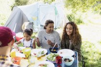 Family enjoying lunch at campsite table — Stock Photo