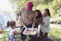 Excited family barbecuing at campsite — Stock Photo