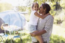 Zärtliche Umarmung von Mutter und Tochter auf sonnigem Campingplatz — Stockfoto
