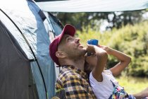 Curious father and daughter bird watching with binoculars at sunny campsite — Stock Photo