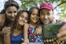 Happy family taking selfie with camera phone — Stock Photo