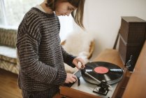 Girl playing vinyl record in living room — Stock Photo