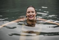 Retrato sonriente joven nadando en el lago - foto de stock