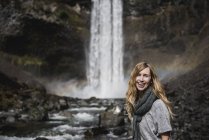 Retrato sonriente, mujer confiada caminando a lo largo de la cascada, Whistler, Columbia Británica, Canadá - foto de stock