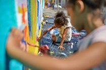 Дівчата малюють фрески на стіні — стокове фото