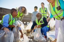 Добровольцы убирают мусор на солнечном пляже — стоковое фото
