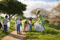 Добровольцы убирают мусор в солнечном парке — стоковое фото