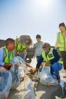 Волонтери прибирають сміття на сонячному пляжі — стокове фото