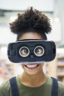 Retrato de un tonto estudiante de secundaria con ojos cruzados que usa un simulador de realidad virtual - foto de stock