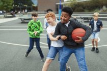 Meninos felizes jogando basquete no pátio da escola — Fotografia de Stock