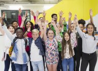 Retrato entusiasta estudiantes de secundaria y profesores animando con los brazos levantados - foto de stock