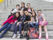 Portrait confident junior high female students on steps — Stock Photo