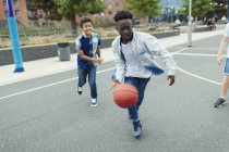 Tween boys playing basketball in schoolyard — Stock Photo