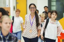 Realschüler laufen lächelnd um Lehrerin herum — Stockfoto