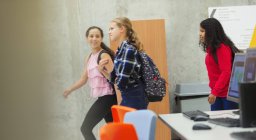 Junior high girl students walking in library — Stock Photo