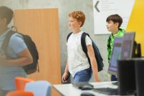 Junior high students walking in library — Stock Photo