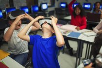 Curiosos meninos do ensino médio usando simuladores de realidade virtual em sala de aula — Fotografia de Stock