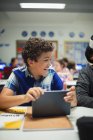Glücklicher Grundschüler mit digitalem Tablet im Klassenzimmer — Stockfoto