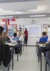 Professora no hijab respondendo a perguntas de alunos em sala de aula — Fotografia de Stock