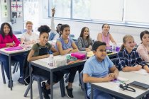 Junior high school students enjoying lesson at desks in classroom — Stock Photo