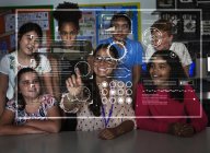 Teacher and junior high school students using futuristic touch screen in classroom — Stock Photo