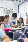 Lehrer hilft Realschülern am Schreibtisch im Klassenzimmer — Stockfoto