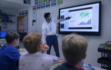 Lehrer leitet Unterricht am Touchscreen im Klassenzimmer — Stockfoto