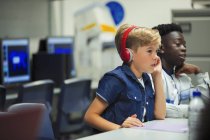 Niño de secundaria enfocado con auriculares en el aula - foto de stock