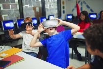 Estudiantes de secundaria utilizando simuladores de realidad virtual en el aula - foto de stock