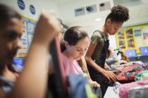 Junior high school students with backpacks in classroom — Stock Photo