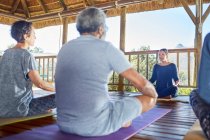 Female yoga instructor leading class in hut during yoga retreat — Stock Photo