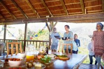 Freunde tragen bei Yoga-Retreat gesundes Essen zu Tisch in Hütte — Stockfoto