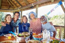 Portrait happy friends enjoying healthy meal in hut during yoga retreat — Stock Photo