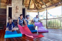People unrolling yoga mats in hut during yoga retreat — Stock Photo