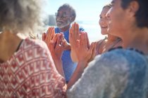 Friends with hands clasped in circle enjoying yoga retreat — Stock Photo