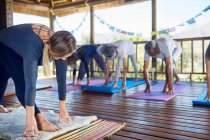 Female instructor leading yoga class in hut during yoga retreat — Stock Photo