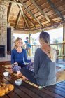 Women talking and drinking tea in hut during yoga retreat — Stock Photo