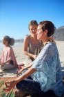 Спокойная женщина медитирует на солнечном пляже во время йоги — стоковое фото