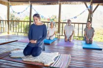 Personas meditando durante el retiro de yoga en la cabaña - foto de stock