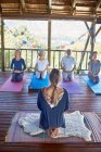 Woman leading meditation in hut during yoga retreat — Stock Photo