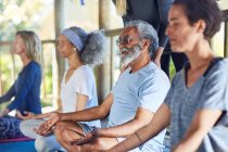 Uomo anziano sereno che medita durante il ritiro yoga — Foto stock