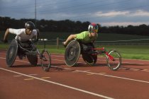 Паралитические спортсмены, мчащиеся по спортивной трассе в гонке на инвалидных колясках — стоковое фото